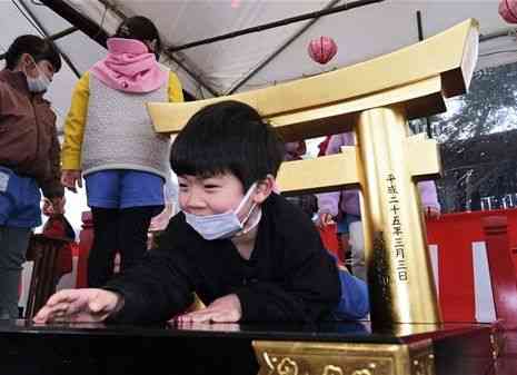 粟嶋神社の春季大祭でミニ鳥居をくぐる子ども＝宇土市