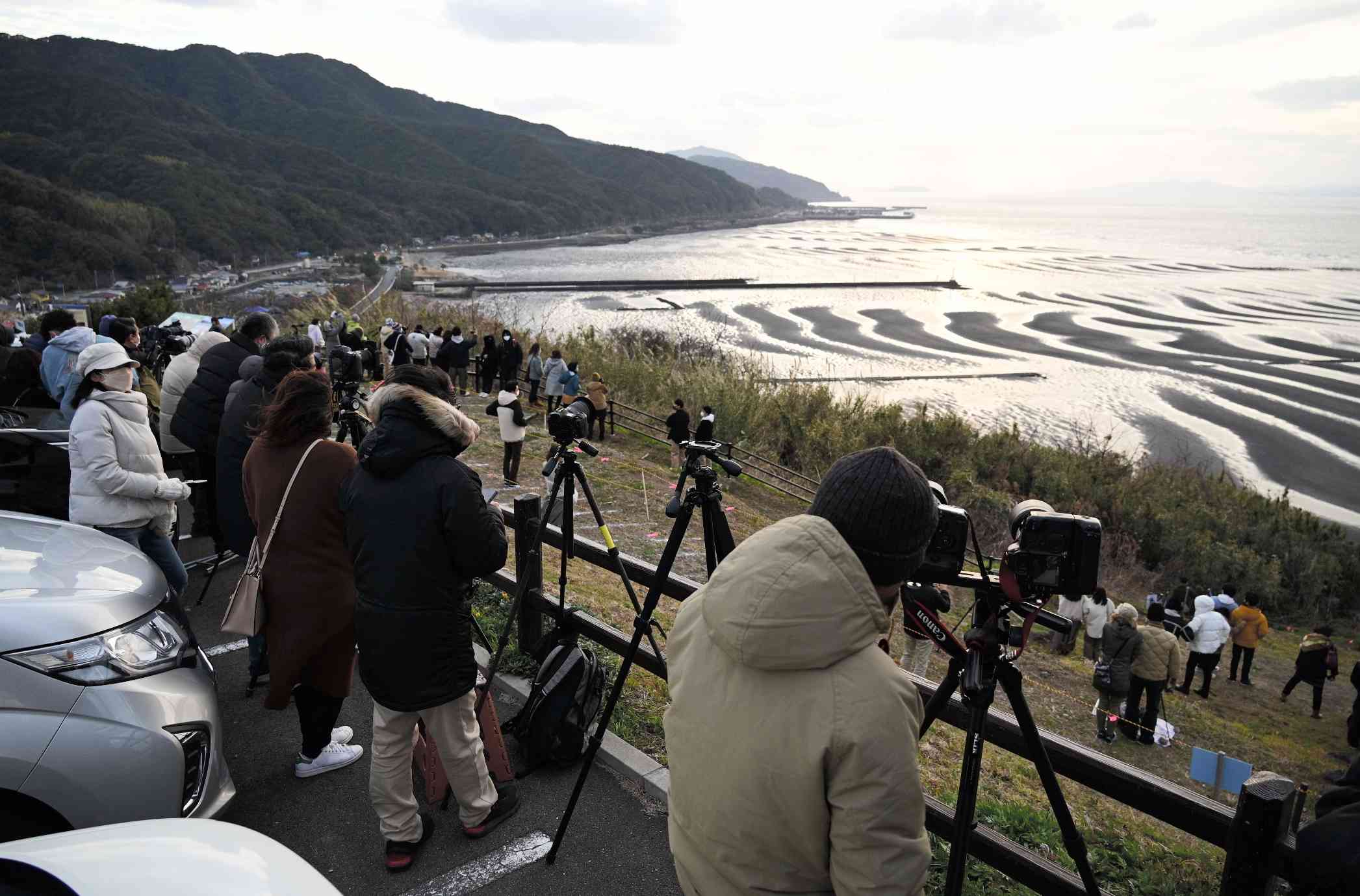 夕日と砂紋が重なる絶景を見ようと約２００人が訪れた御輿来海岸の展望所＝２月、宇土市