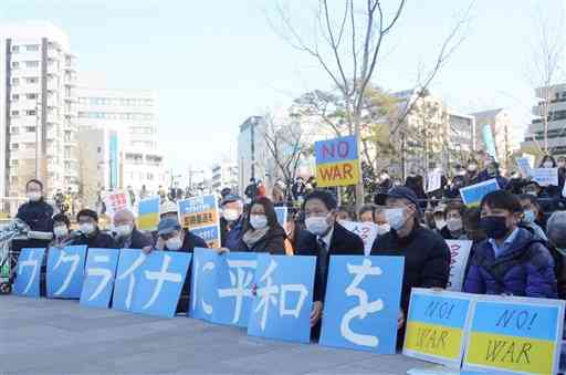 「ウクライナに平和を」の文字をパネルで並べ、抗議の座り込みをする集会の参加者＝３日、熊本市中央区