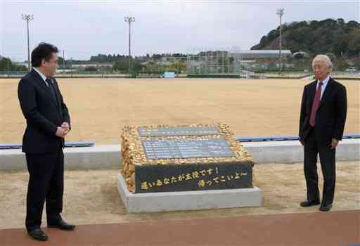 大矢野総合スポーツ公園に設置した50回大会記念碑を見つめる堀江隆臣市長（左）と熊本走ろう会の出田秀尚会長＝上天草市