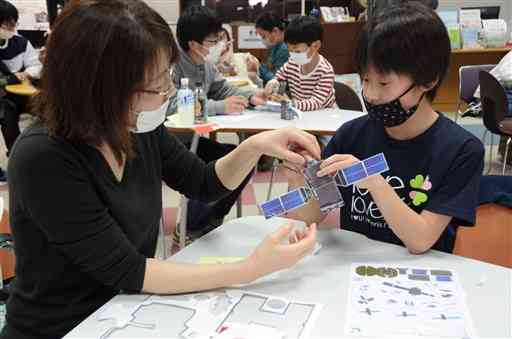 人工衛星のペーパークラフト作りに挑戦する子どもたち＝熊本市中央区