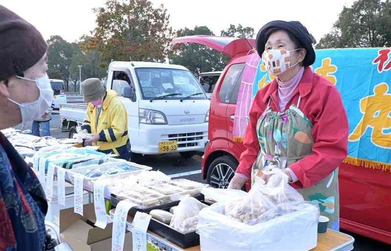 ましきメッセもやい市で接客する牛深朝市会の田中裕美さん（右）＝益城町