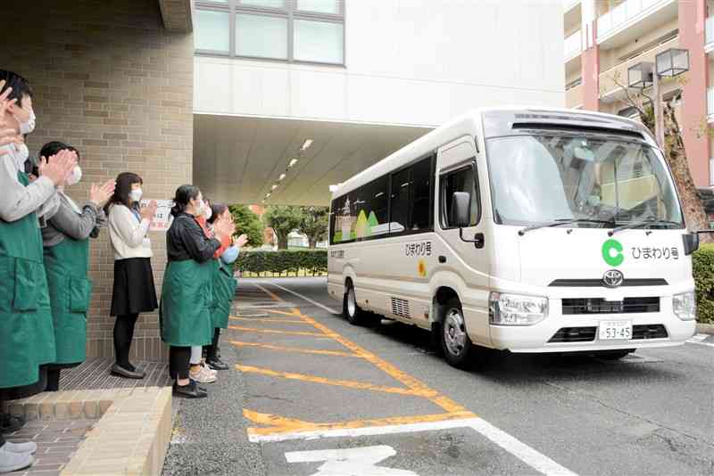 職員が拍手を送る中、初めての巡回に出発する「ひまわり号」＝熊本市中央区