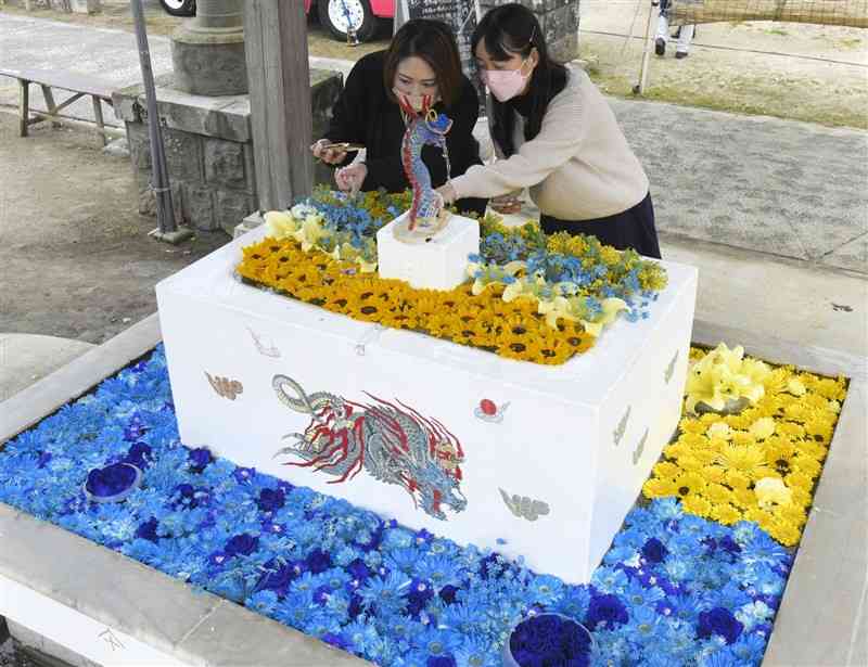 ウクライナの国旗の色である青と黄色に飾られた四王子神社の「花手水」＝長洲町