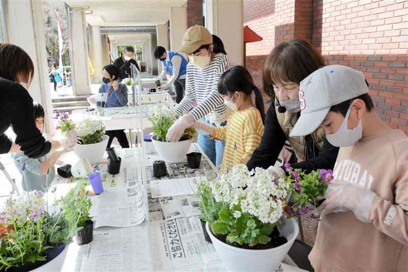 「水辺エリア」のオープニングイベントで、寄せ植えをする親子連れら＝熊本市東区