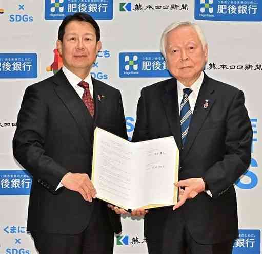 SDGs推進に関する連携協定を結んだ肥後銀行の笠原慶久頭取（左）と熊日の河村邦比児社長＝２２日、熊本市中央区の同行本店（後藤仁孝）