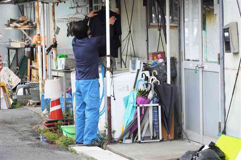 中央・西区土木センターの屋外にある洗濯機で服を洗う職員＝１７日、熊本市西区