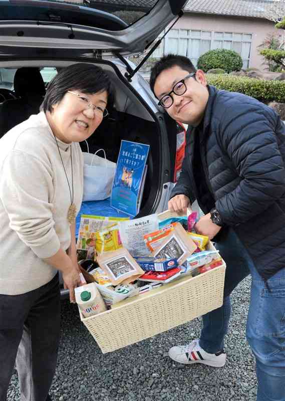 寄せられた食品をフードバンクの茶木谷与和さん（右）に手渡す古閑恵子さん＝菊池市