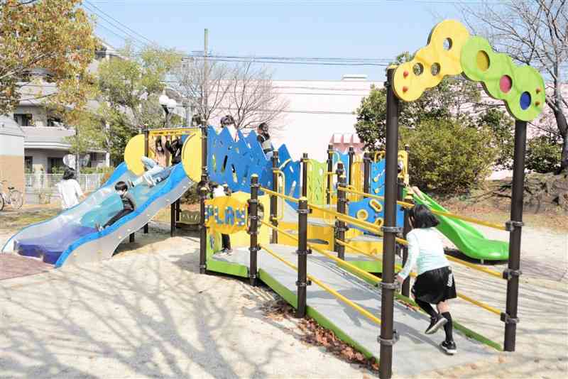 スロープや手すりの付いた複合遊具で遊ぶ子どもたち＝熊本市南区