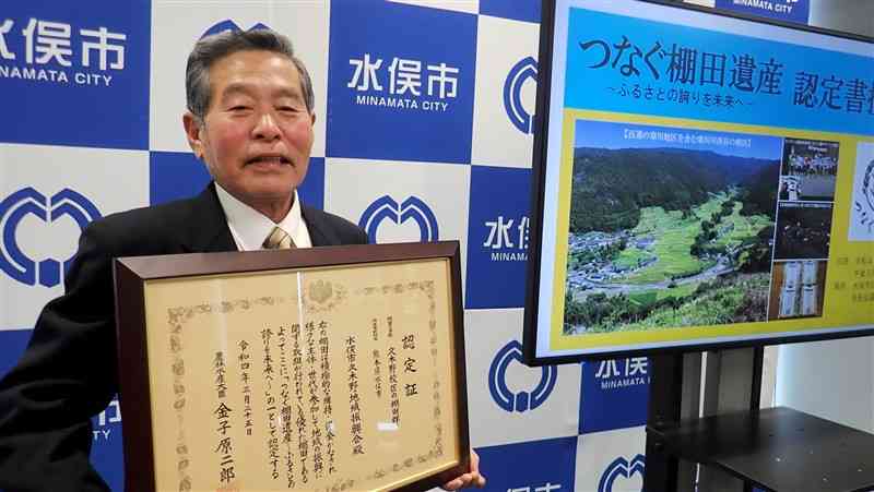 「つなぐ棚田遺産」の認定証を受け取った久木野地域振興会の本井三千年会長＝水俣市