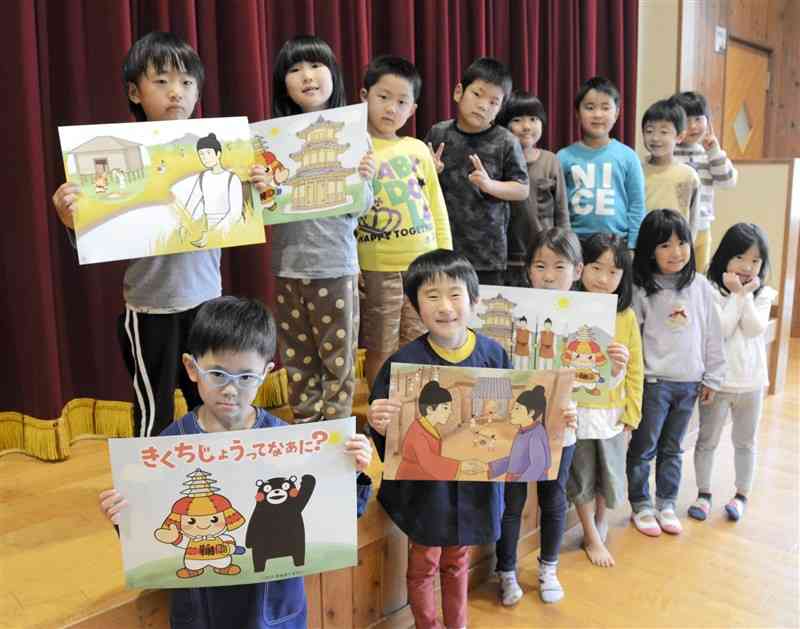 鞠智城を紹介する紙芝居を手にする鹿本こども園の園児たち＝山鹿市