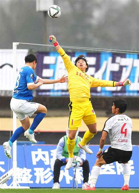 【熊本－水戸】前半、ゴール前で競り合い、パンチングする熊本のGK田代（中央）＝水戸市のケーズデンキスタジアム水戸