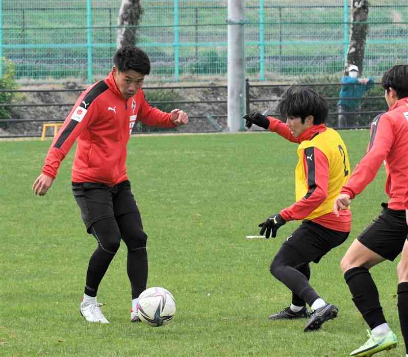 28日の練習でパスを出すFW粟飯原（左）＝県民総合運動公園サッカー場