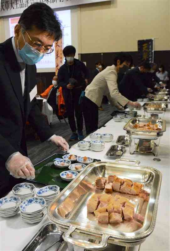 生産者が出品した天草大王のモモ肉を取り分ける審査員＝29日、熊本市中央区