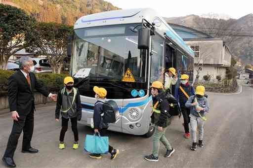 電気自動車（ＥＶ）のスクールバスを走らせる実証事業で、バスから降りてきた児童＝球磨村