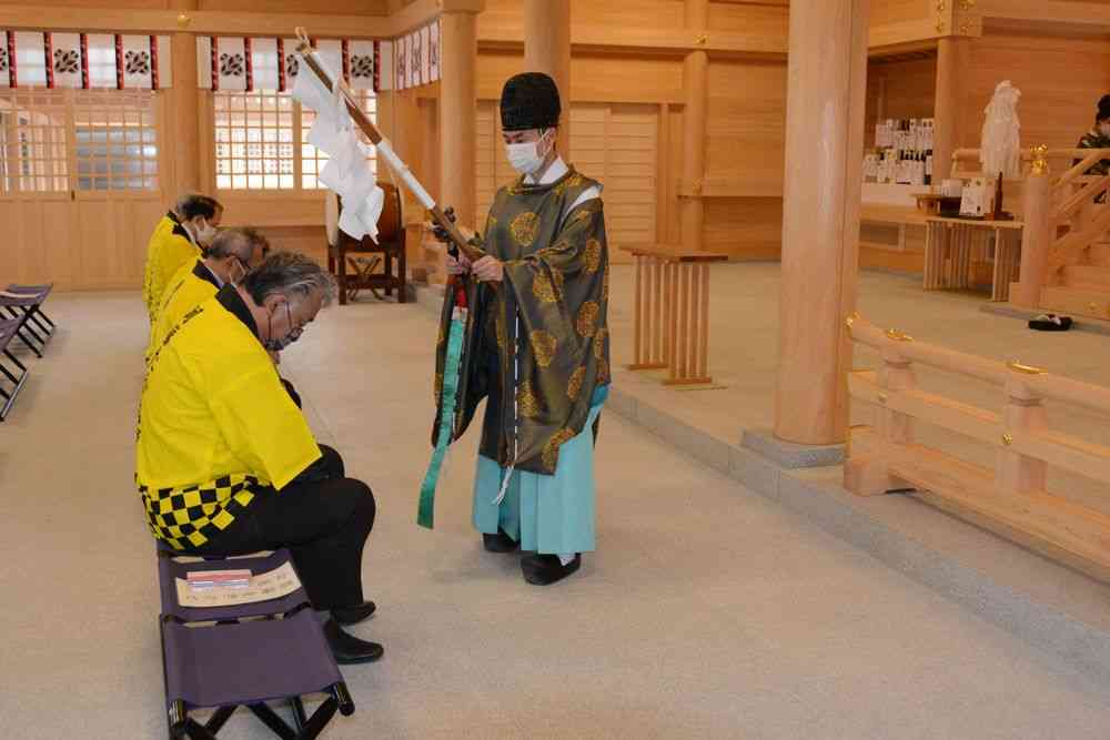 タカナの豊作と商売繁盛を祈り、阿蘇神社に出来たての新漬けを奉納した阿蘇たかな漬協同組合の組合員ら＝13日、阿蘇市