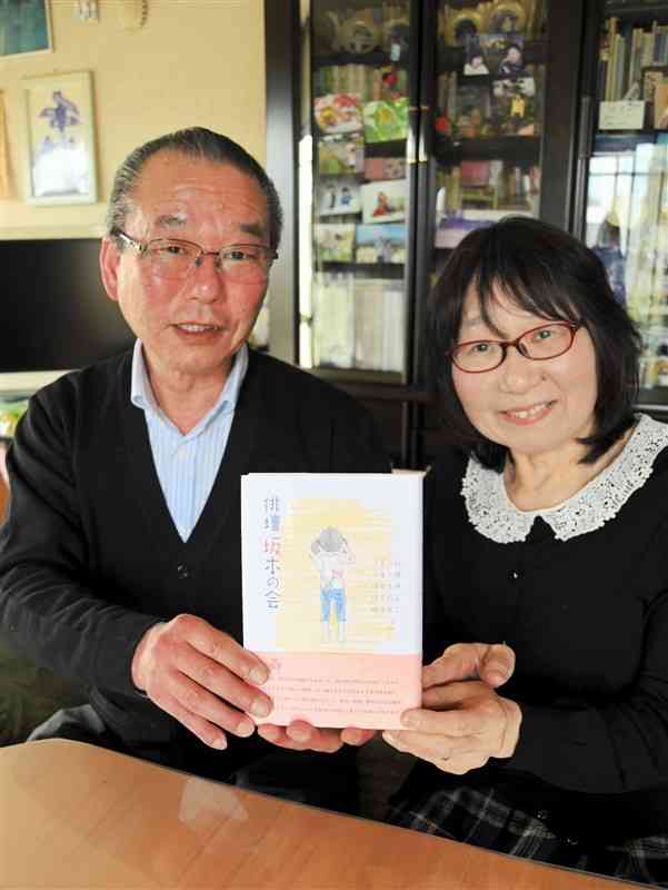 かつて家族が集ったリビングで句集「俳壇坂本の会」を手にする坂本真二さん、節子さん夫妻＝宇土市