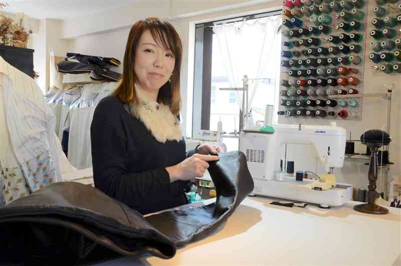 ズボンの裾上げをするコアトリエの大山愛美さん。「服をお直しして使い続ける人が増えている」と言う＝熊本市中央区