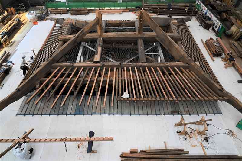 復旧工事が進む阿蘇神社楼門の上層部分。屋根を支える木材を扇状に配置する「扇垂木」と呼ばれる最高難度の技術が見られる＝阿蘇市