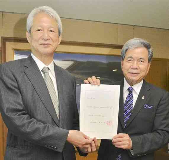 蒲島郁夫知事（右）から県立大理事長に再任された白石隆氏＝1日、県庁