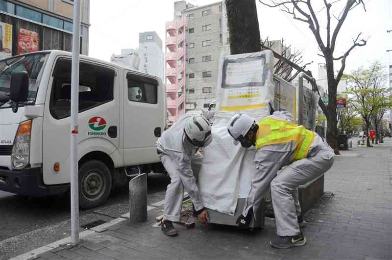 シャワー通りにあった公設灰皿を撤去する業者＝3月下旬、熊本市中央区
