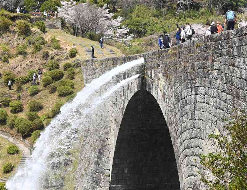 通潤橋の今期初の放水を橋上から見学する観光客ら＝山都町