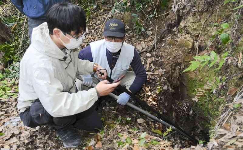 地下壕内を小型カメラで調査する「くまもと戦争遺跡・文化遺産ネットワーク」のメンバーら＝熊本市北区