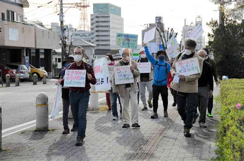 瀬戸石ダムの撤去を訴えながら市街地を練り歩く抗議集会の参加者ら＝2日、八代市