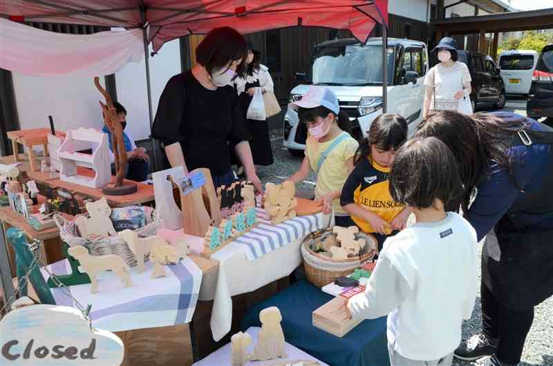 西福寺の「ご縁マルシェ」で木工雑貨を眺める子どもたち＝氷川町