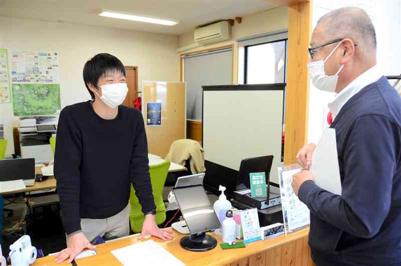 地元業者の相談に乗るみなみあそ観光局の久保尭之マネジャー（左）＝4日、南阿蘇村