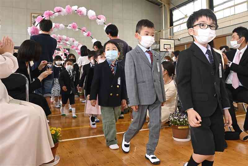 緊張した面持ちで入学式会場に入る大江小の新1年生＝13日午前、熊本市中央区（小野宏明）