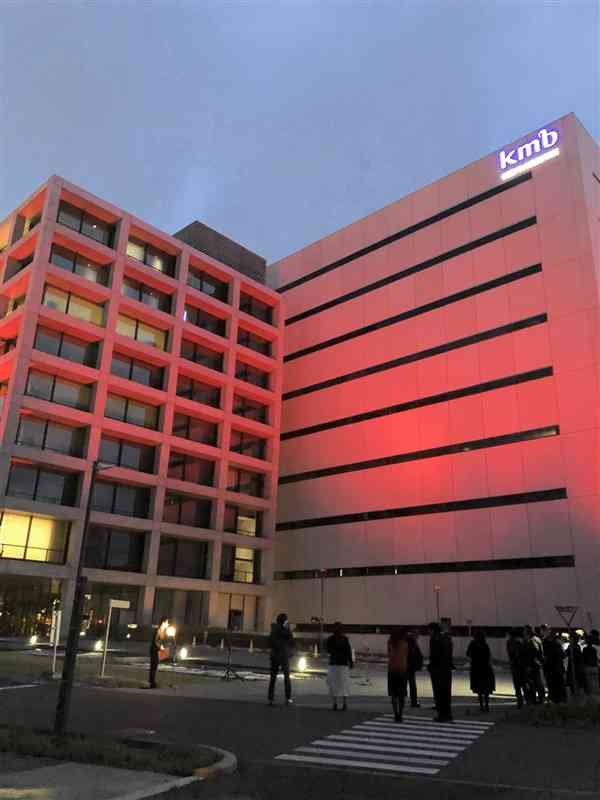 世界血友病デーに合わせ、赤色にライトアップされたKMバイオロジクスの本社建屋＝15日、熊本市