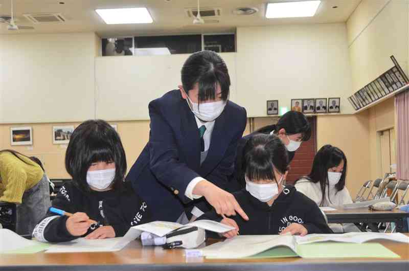 小国高生に教わりながら社会科の問題を解く子どもたち＝南小国町