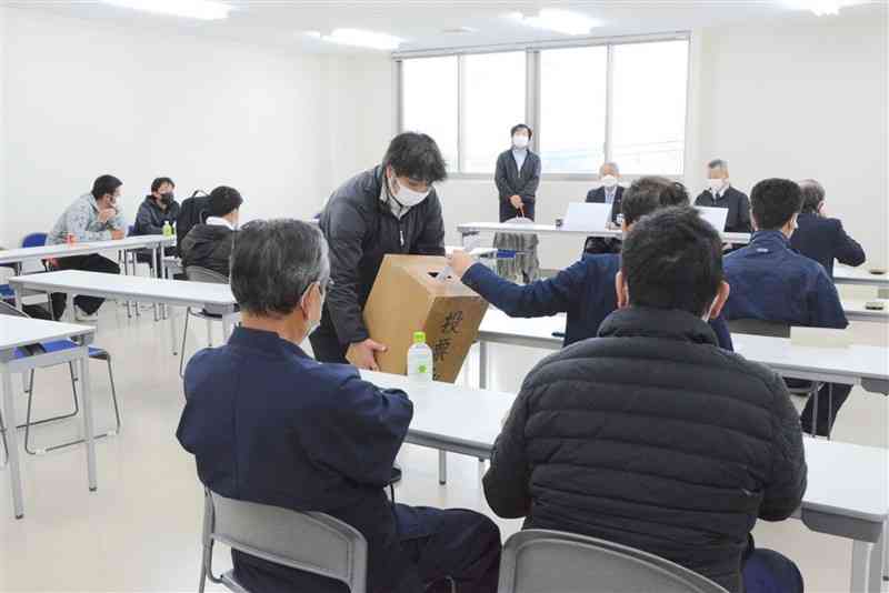 出荷再開後2度目となる県産アサリの入札会で、希望価格を提示する指定商社の担当者＝21日、熊本市西区