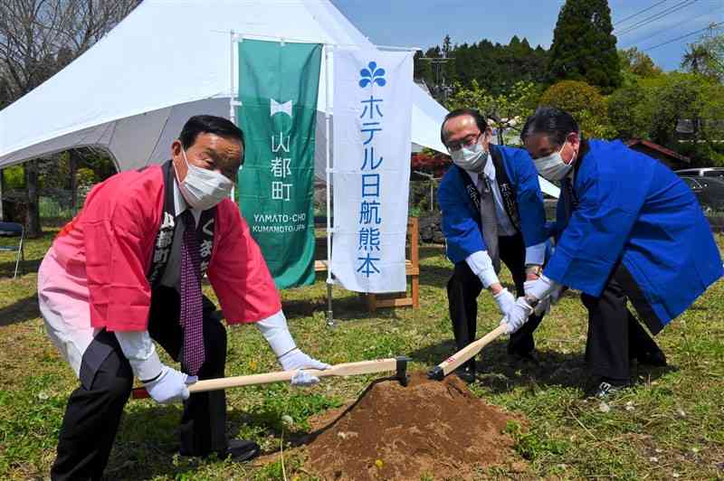 くわ入れ式に臨むホテル日航熊本の川﨑博社長（中央）ら＝山都町