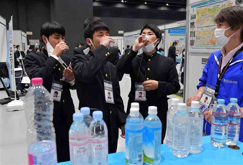 第4回アジア・太平洋水サミットの現地展示会で、国内外の水を試飲する高校生たち＝熊本市中央区の熊本城ホール（後藤仁孝）