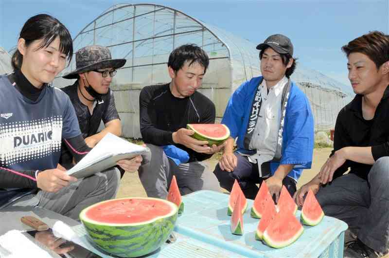 スイカの味の特徴などについて米田謙一さん（左から3人目）から説明を受ける植木町4Hクラブのメンバーら＝熊本市北区