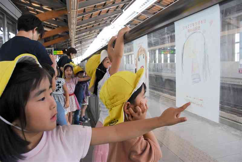 新幹線新玉名駅のホームに母親の似顔絵を貼った園児たち＝玉名市