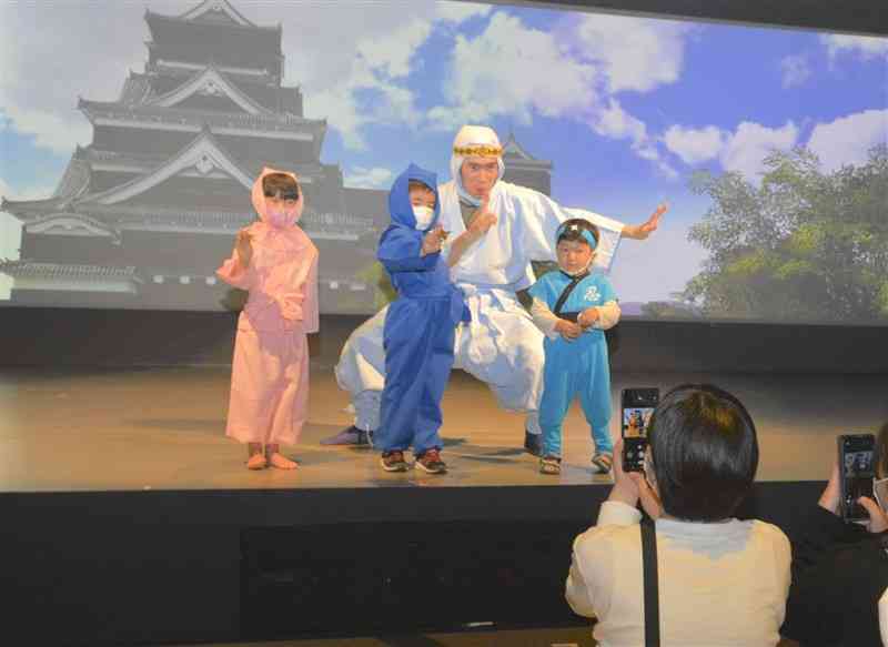 忍者姿の演者と一緒に写真に納まる子どもたち＝熊本市中央区