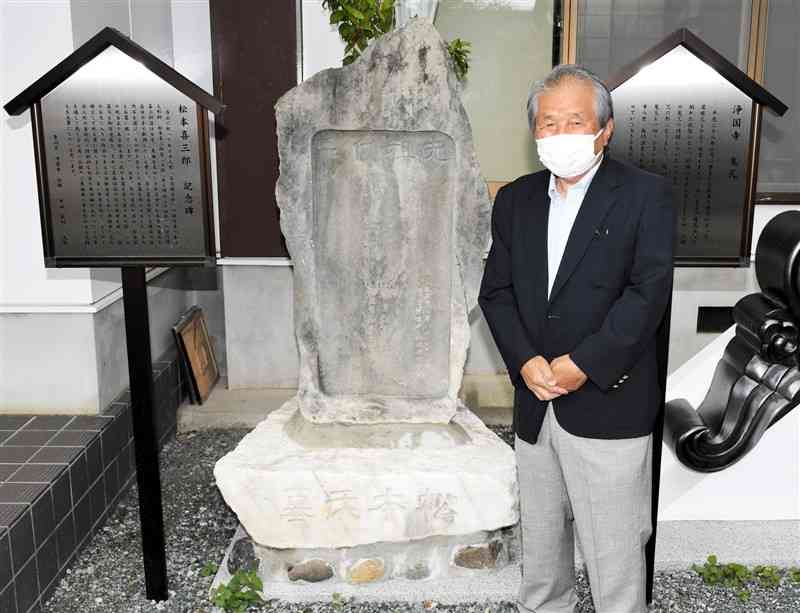 浄国寺に設置された松本喜三郎祈念碑と、子孫の松本秀一さん＝熊本市北区