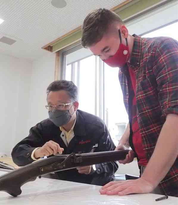 400年以上前の火縄銃を調べるサミュエルさん（右）。左は葦北鉄砲隊の平江大八隊長＝芦北町