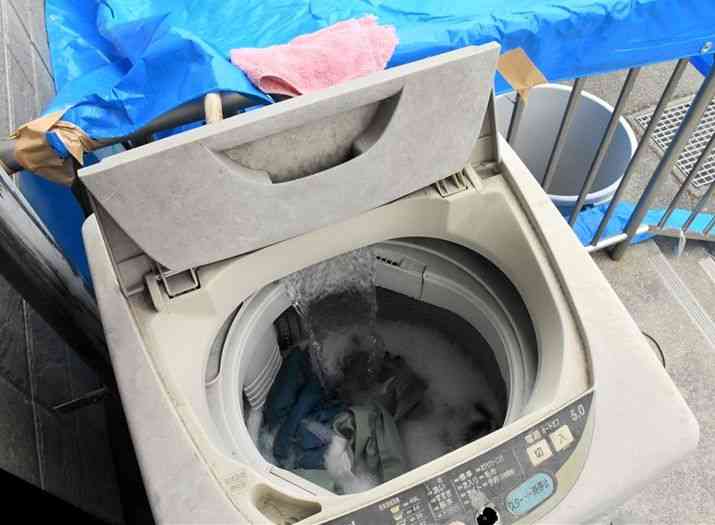 洗濯排水の水質調査のため、作業着と手袋を洗う中央・西区土木センターの洗濯機＝31日、熊本市西区