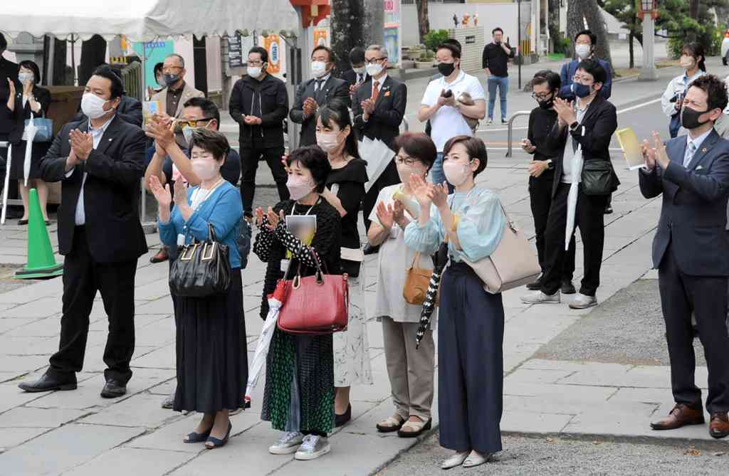 県議補選が始まり、出陣式で候補者に拍手を送る支持者ら＝20日午前、熊本市（チラシなどの一部は加工しています）