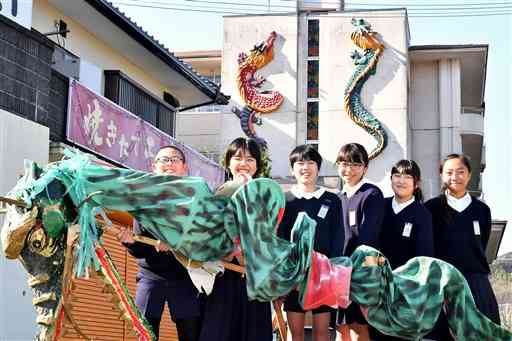 校舎に設置された竜の模型と一緒に写真に納まる池上小の子どもたち＝熊本市西区（2017年12月撮影、池田祐介）