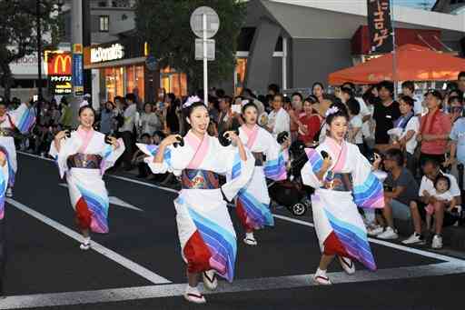 2019年の祭りで、陽気なハイヤ踊りで通りを練り歩く踊り手＝天草市