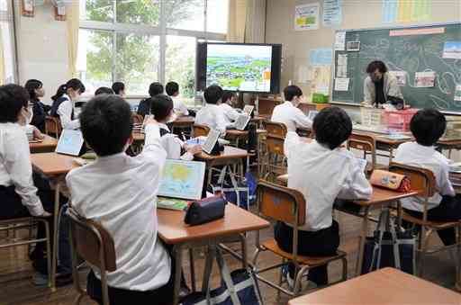 タブレット端末と電子黒板を使った熊本市内の中学校の授業風景。仕事の環境も、教員が人事交流を希望するかどうかの判断材料になっている＝2021年11月