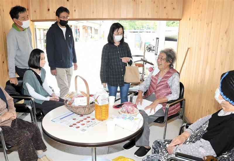 サロンに立ち寄った観光客らと談笑する船津智惠子さん（右から2人目）。左端は長男の悦男さん＝天草市