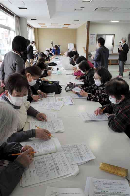 「人生会議」セミナーで、実際にメッセージノートを書いてみる参加者＝3月、熊本市南区