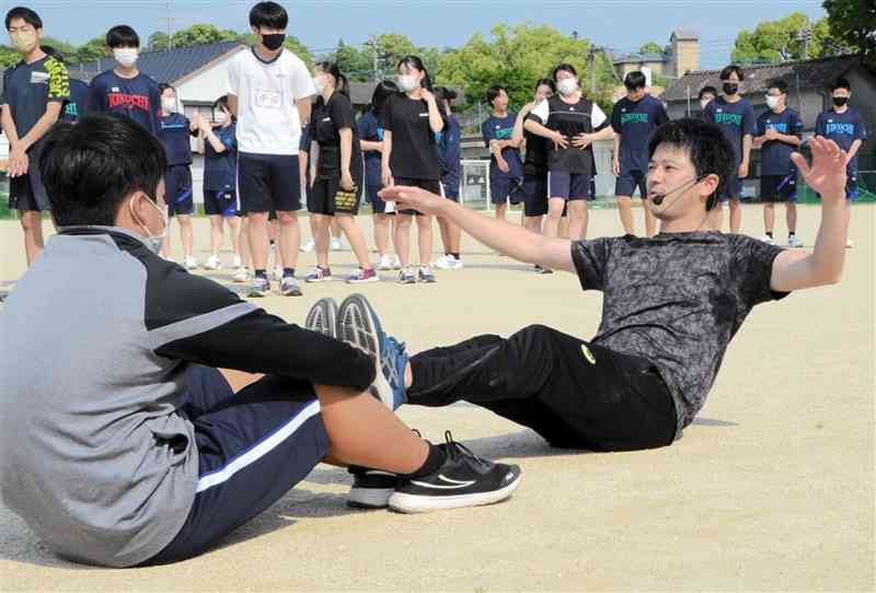 トレーニング方法をアドバイスする江里口匡史さん（右）＝菊池市