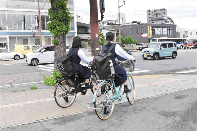 自転車で下校中に信号を待つ高校生。周辺は多くの自転車が行き交っていた＝6日午後5時、熊本市中央区